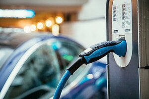 Borne de recharge électrique avec voiture en arrière-plan